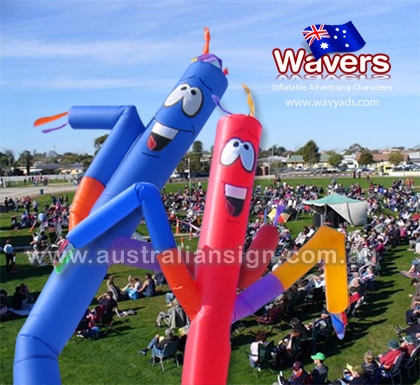 Two inflatable advertising charactes being blown up and used at a public event
